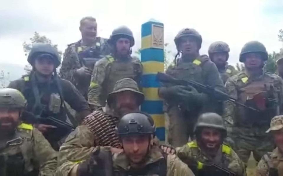 Ukrainian fighters mark their victory with a border sign on the Russian frontier - Ukrainian ministry of defence 