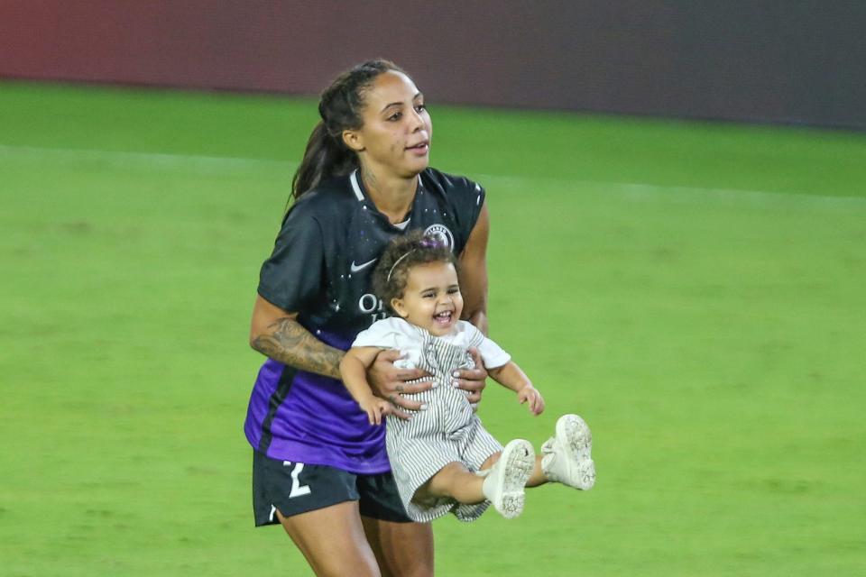 Orlando Pride forward Sydney Leroux holds her daughter, Roux, after an NWSL Challenge Cup soccer match against Gotham in 2021. She also has a son Cassius.