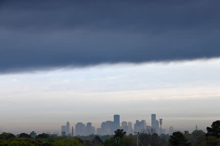 A thick layer of smoke from a fire burning at the Intercontinental Terminals Company in Deer Park hangs in the air above the downtown skyline of Houston, Texas, U.S., March 18, 2019. REUTERS/Loren Elliott