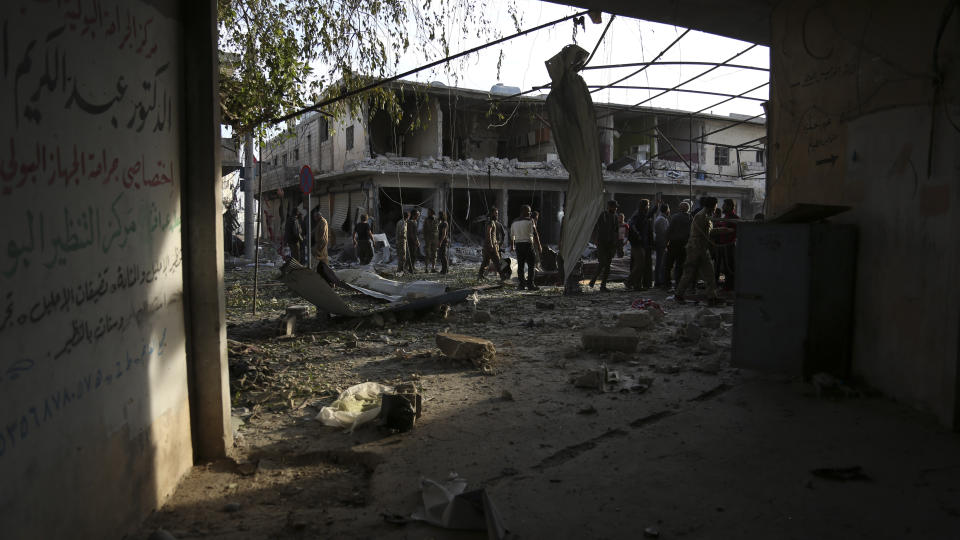 People check the destruction after a car bomb exploded in Tal Abyad, Syria, Friday, Nov. 2, 2019. A car bomb exploded in a northern Syrian town along the border with Turkey Saturday killing over a dozen of people, Turkey's defense ministry said. (AP Photo)