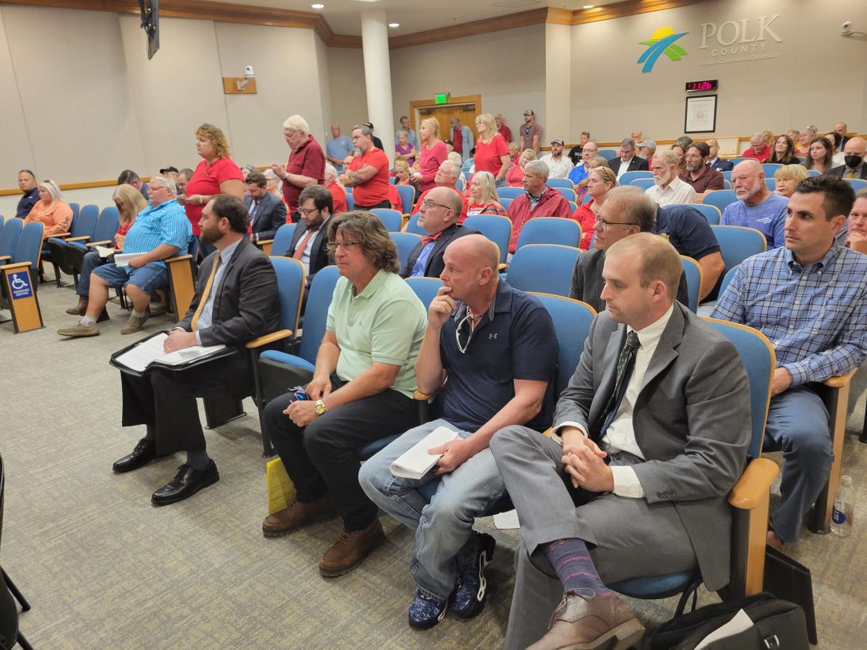 Residents dressed in red t-shirts line up to speak in opposition to a racetrack proposed by Gary Young of Melbourne. Young, seated in the front row, second from the right, had hoped to move forward with his dream of racing cars on his property, but commissioners rejected the plan.