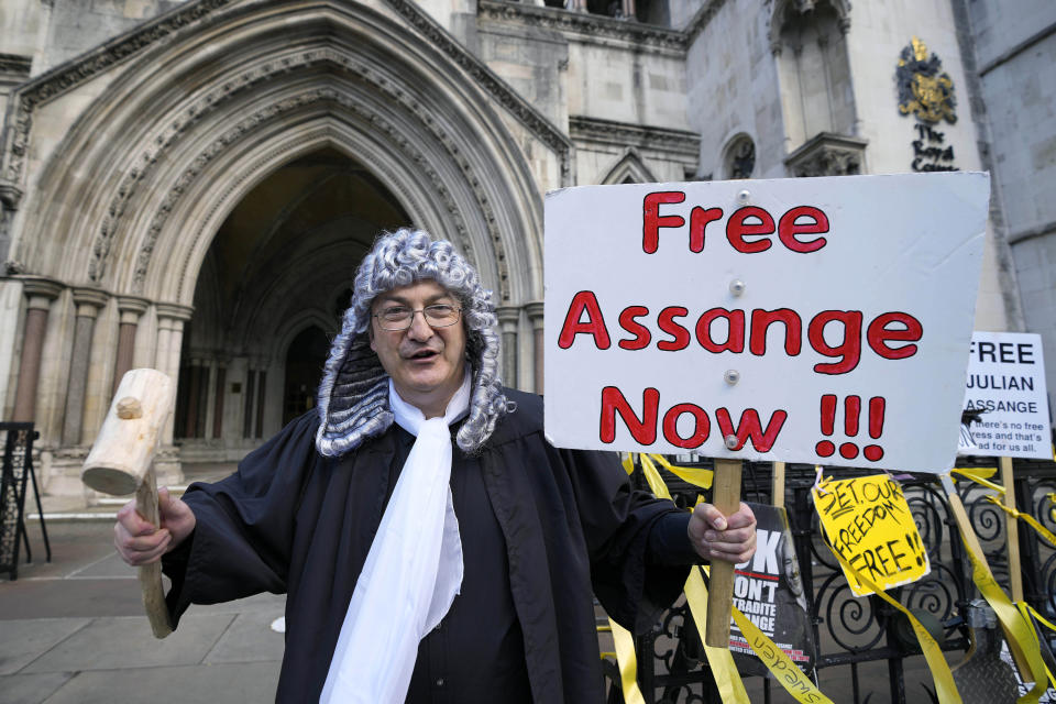 A supporter of Julian Assange, dressed as a judge demonstrates outside the High Court in London, Thursday, Oct. 28, 2021. The U.S. government is scheduled to ask Britain's High Court to overturn a judge's decision that WikiLeaks founder Julian Assange should not be sent to the United States to face espionage charges. A lower court judge refused extradition in January on health grounds, saying Assange was likely to kill himself if held under harsh U.S. prison conditions. (AP Photo/Frank Augstein)