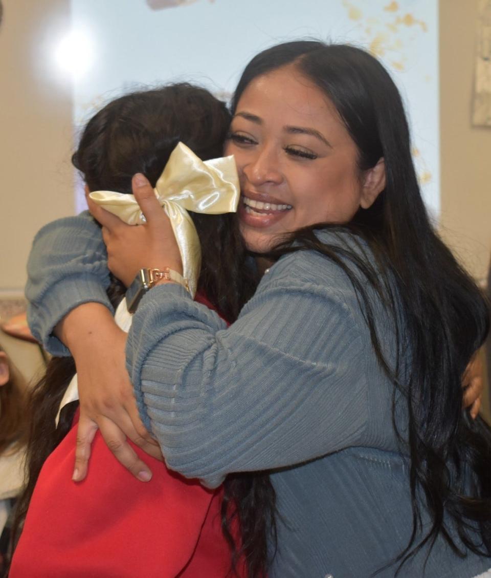 This year's Wichita Falls ISD Christmas card design winner, Cunningham Elementary School fifth grader Giselle Fernandez, left, gets a hug from her mom, Bianca Hernandez, a paraprofessional at Cunningham, after being recognized for her artwork Nov. 30, 2023.
