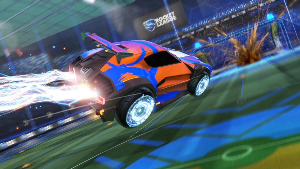 A blue car with orange decals zooming across the pitch using its rocket boosters