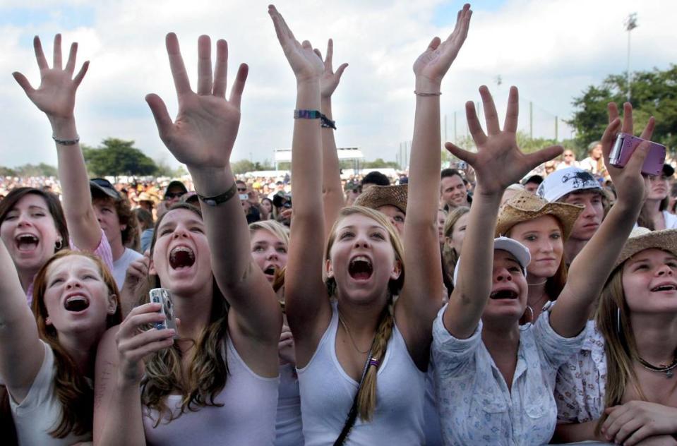 En esta foto de archivo del 27 de enero de 2008, fans de Taylor Swift muestran su entusiasmo por la entonces adolescente artista de música country durante la actuación de Swift en el 23º concierto y concurso anual 99.9 KISS County Chili Cookoff en el C. B. Smith Park. Más de 20,000 aficionados a la música country y 87 equipos de cocineros de chili acudieron al concierto y a la feria.