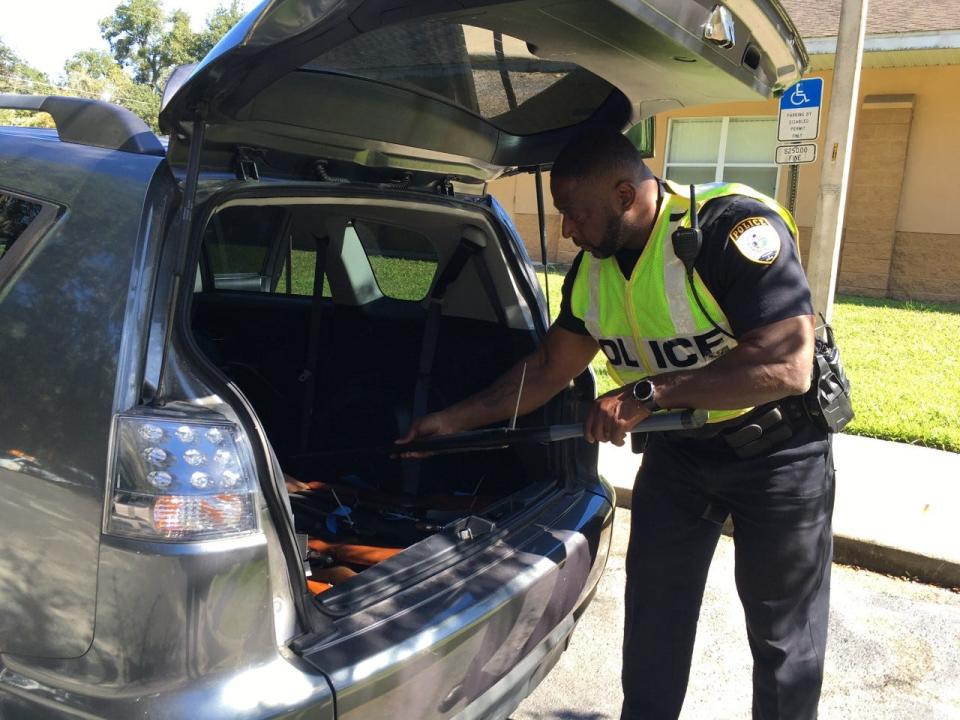 Gainesville Police Officer Doug Williams with a gun collected in Saturday's gun buyback. The guns are destroyed.