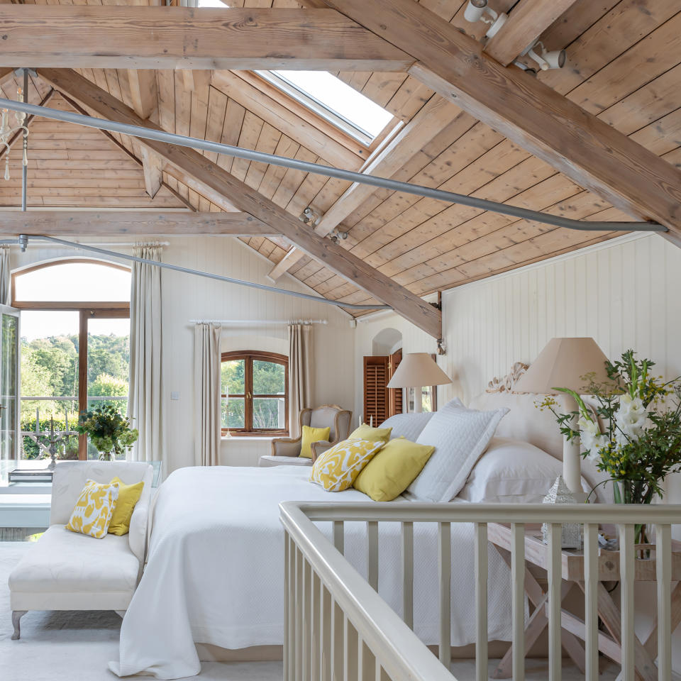 large bedroom with wood-panelled vaulted ceiling and French doors to the balcony