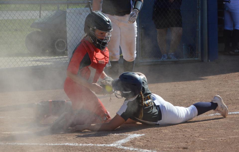 Kaitlyn Poe of Airport is tagged out at home plate by Grosse Ile catcher Sophia Kronnell while trying to score on a wild pitch. Airport won 10-0.