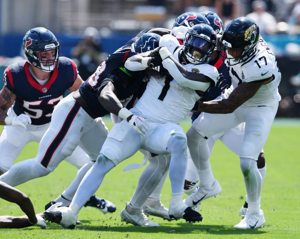 Travis Etienne of the Jaguars (1) tries to pull away from Houston defenders during the second quarter of Sunday's game against the Houston Texans in EverBank Stadium.
