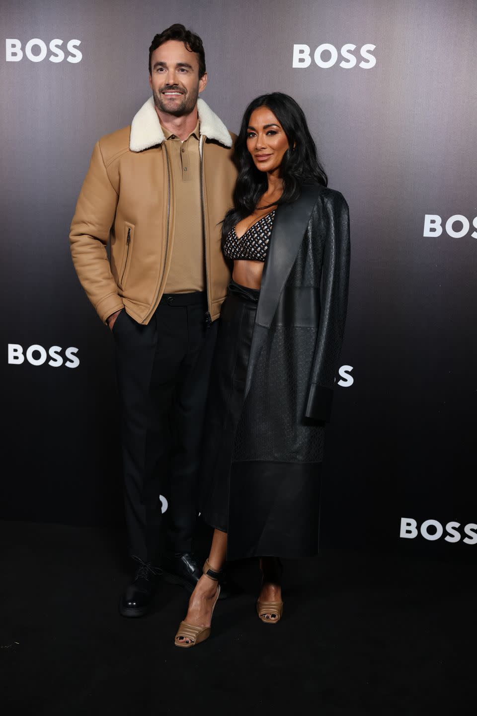 thom evans and nicole scherzinger smiling and posing for cameras at milan fashion week in september 2022