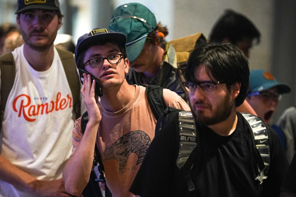 Hunter Kersh calls a friend on his phone while waiting in a security line at Austin-Bergstrom on June 29. After dealing with packed ticket counters and long security lines, Kersh said he called a friend to try to find out which security line he was supposed to be in.