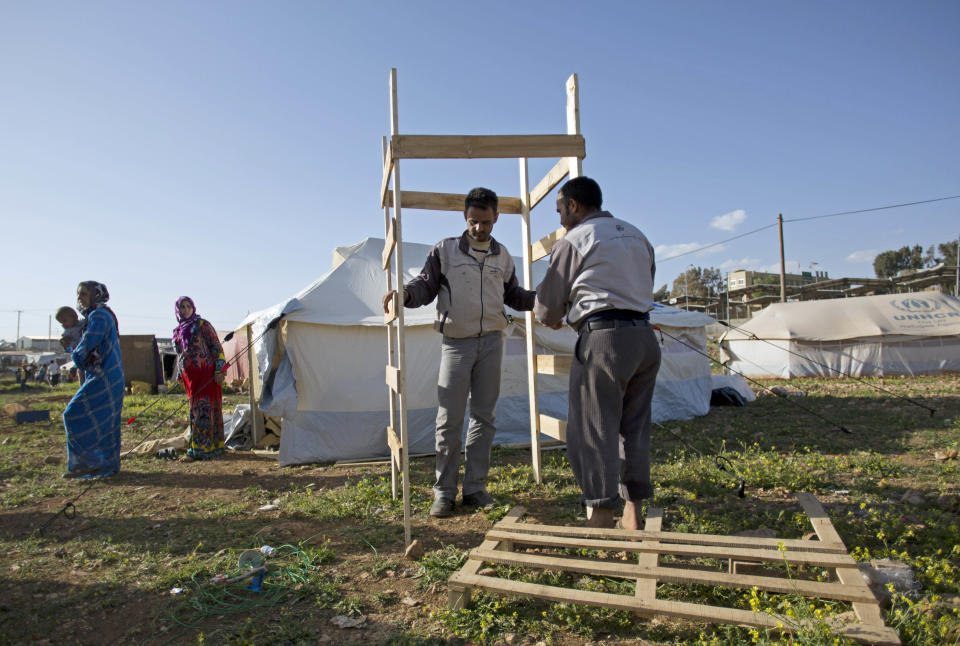 In this Tuesday, April 8, 2014 photo, Syrian refugees build a wooden rest room next to their tent in an unofficial refugee camp on the outskirts of Amman. Some Syrians have set up informal camps to flee the tensions at Zaatari, the region's largest camp for Syrian refugees, and to be closer to job opportunities. (AP Photo/Khalil Hamra)