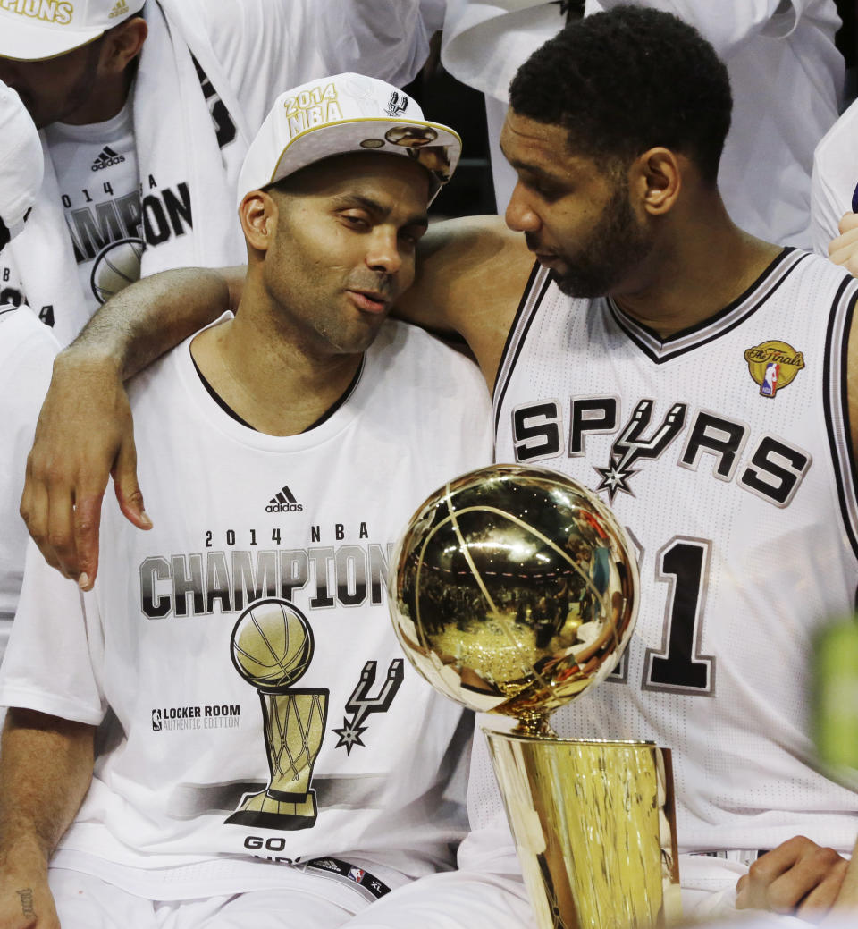 FILE - In this June 15, 2014, file photo, San Antonio Spurs guard Tony Parker, left, and forward Tim Duncan celebrate after Game 5 of the NBA basketball finals in San Antonio. The Spurs won the NBA championship 104-87. Duncan announced his retirement on Monday, July 11, 2016, after 19 seasons, five championships, two MVP awards and 15 All-Star appearances. It marks the end of an era for the Spurs and the NBA. (AP Photo/David J. Phillip, File)