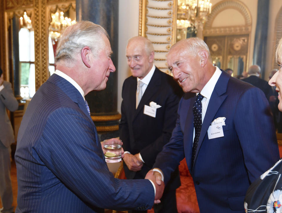 FILE - Britain's Prince Charles, left, shakes hand with Len Goodman, during a reception for Age UK at Buckingham Palace in London, June 6, 2018. Len Goodman, an urbane long-serving judge on “Dancing with the Stars” and “Strictly Come Dancing,” has died, his agent said Monday, April 24, 2023. He was 78. A former dancer, Goodman was a judge on “Strictly Come Dancing” for 12 years from its launch on the BBC in 2004. (John Stillwell/PA via AP, File)