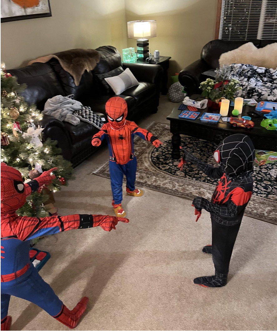 Kids dressed as Spider-Man pointing to each other