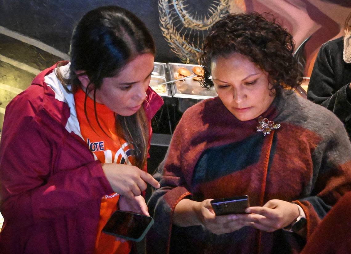 Veronica Garibay, left, co-director of Leadership Counsel for Justice and Accountability, and Sandra Celedon, CEO of Fresno Building Healthy Communities, check early election results while gathering with supporters who are against the renewal of Measure C during a election night watch party at Vibez Lounge in Fresno’s Tower District on Tuesday, Nov. 8, 2022. CRAIG KOHLRUSS/ckohlruss@fresnobee.com