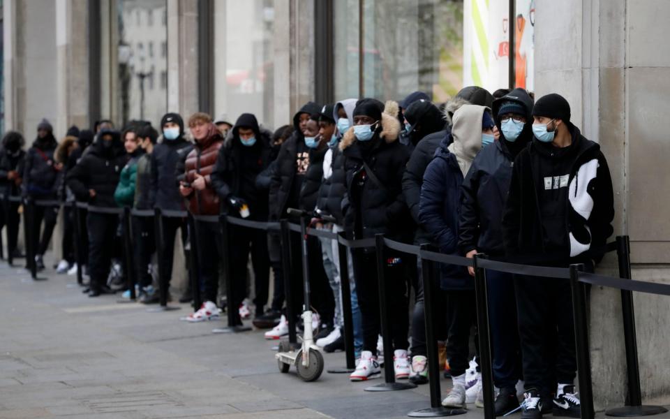 A queue grows big as people wait to enter a Nike Town shop on Oxford Street in London, early Monday morning, April 12, 2021 - Kirsty Wigglesworth 