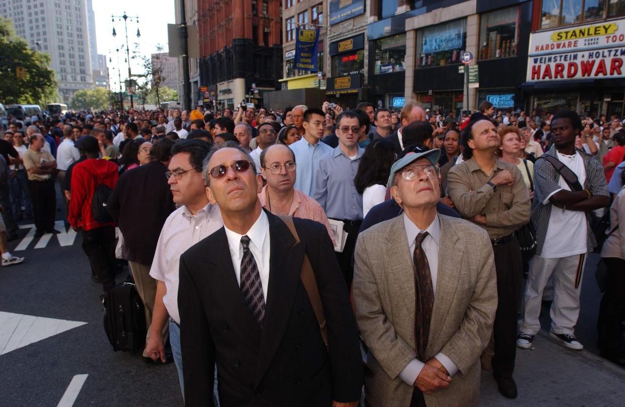 Spectators look up as the World Trade Center goes up in flames September 11, 2001 in New York City after two airplanes slammed into the twin towers in an alleged terrorist attack.