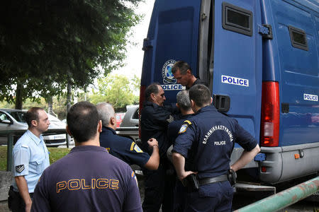 Alexander Vinnik, a 38 years old Russian man suspected of running a money laundering operation using bitcoin, is escorted by police officers to the court in Thessaloniki, Greece, September 29, 2017. REUTERS/Alexandros Avramidis