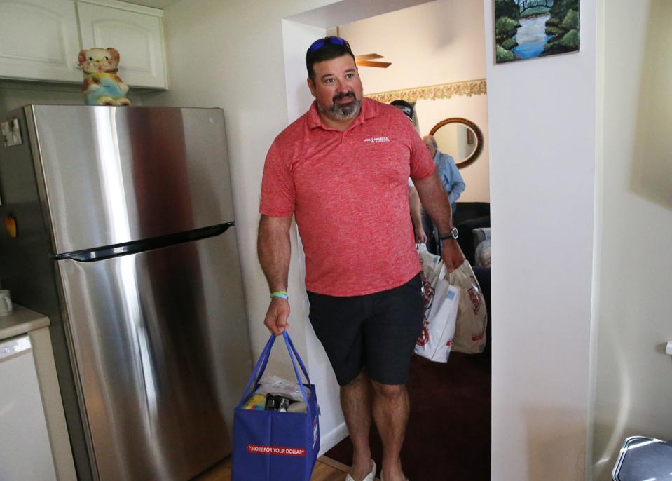 Former New England Patriot offensive lineman Joe Andruzzi helps deliver groceries to Stratham's Rudy Longo, a 91-year leukemia and prostate cancer patient, Wednesday, Sept. 13, 2023.