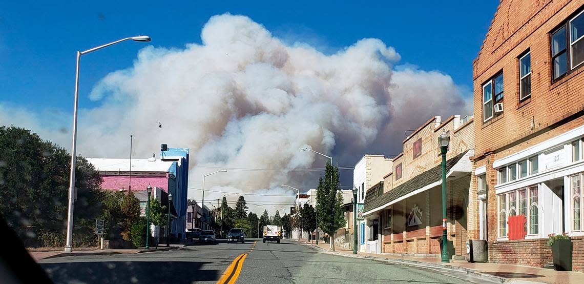 A plum of smoke covers the sky as the the Mill Fire approaches in Weed, Calif. Friday, Sept. 2, 2022.