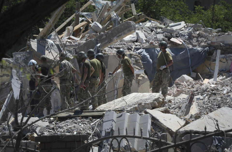 FILE - Ukrainian State Emergency Service firefighters work at damaged residential building in the town of Serhiivka, located about 50 kilometers (31 miles) southwest of Odesa, Ukraine, July 1, 2022. While much of the attritional war in Ukraine’s east is hidden from sight, the brutality of Russian missile strikes in recent days on the mall in the central city of Kremenchuk and on residential buildings in the capital, Kyiv, were in full view to the world and especially to Western leaders gathered for a trio of summits in Europe. (AP Photo/Nina Lyashonok, File)