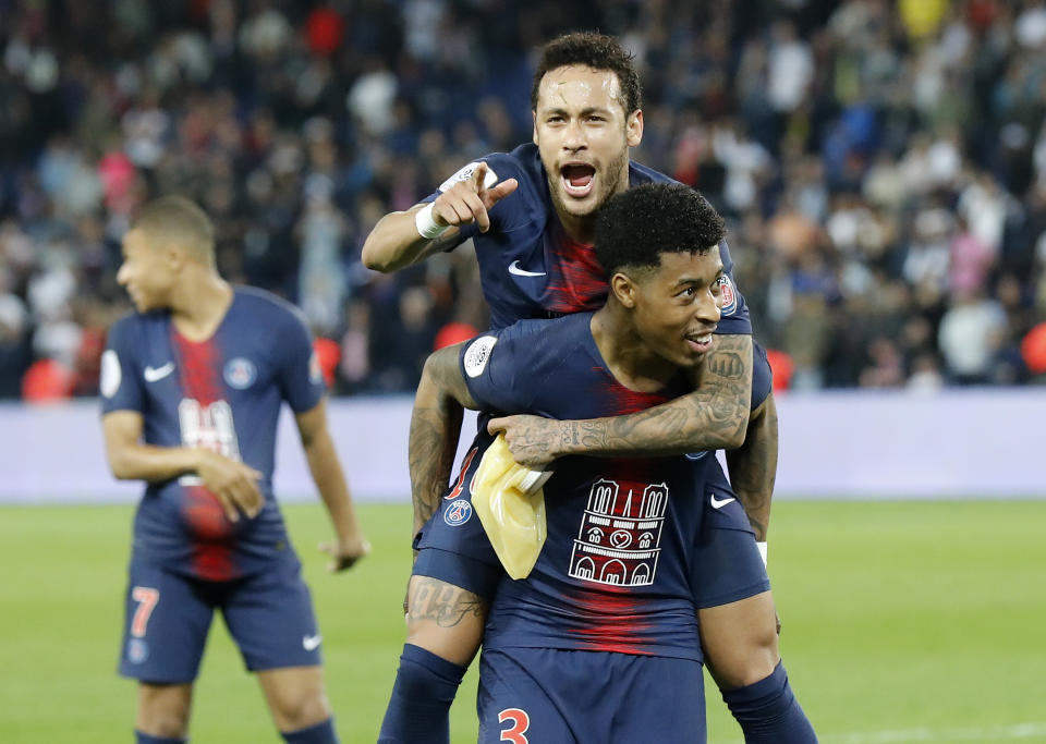 PSG's Neymar, top, sits on the back of PSG's Presnel Kimpembe after the French League One soccer match between Paris-Saint-Germain and Monaco at the Parc des Princes stadium in Paris, Sunday April 21, 2019. PSG were celebrating winning the French League one title. (AP Photo/Michel Euler)