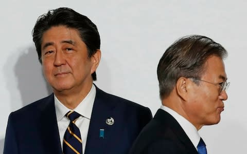 Japan's Shinzo Abe and South Korea's Moon Jae-in, whose countries are at odds over WW2 reparations - Credit: Kim Kyung-hoon/AP