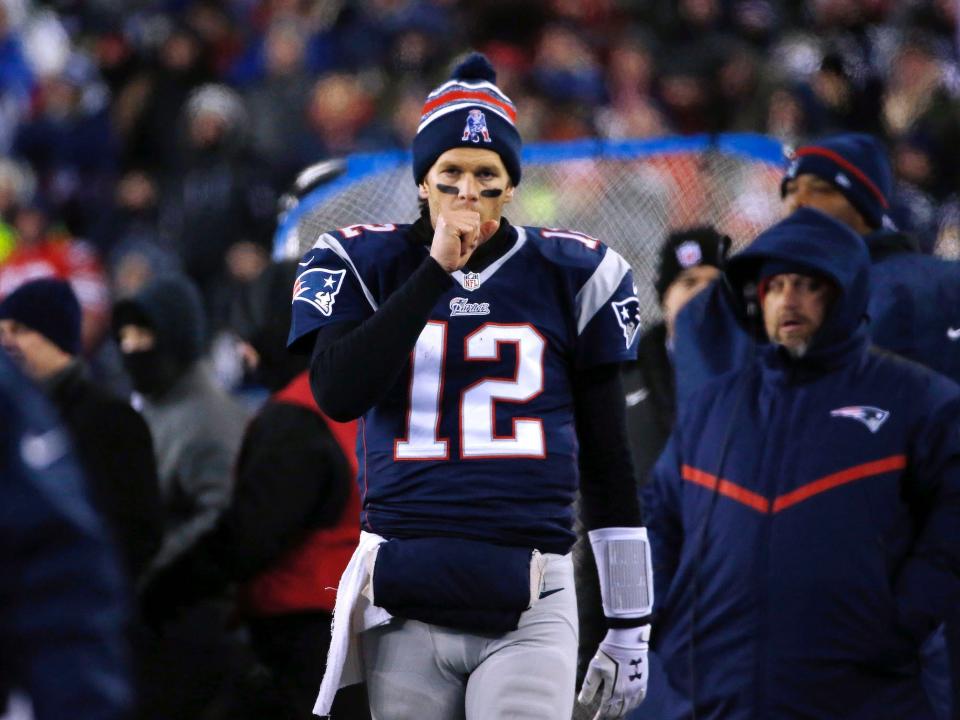 Tom Brady walks on the sideline and blows into his hand in 2015.