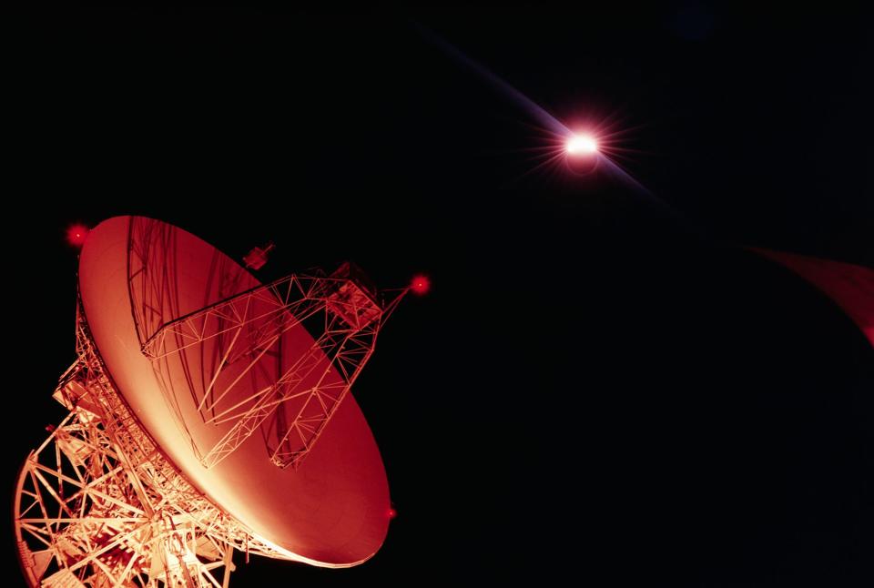 A large antenna dish beneath a solar eclipse