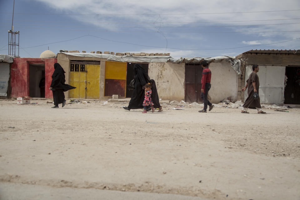 People walk in the marketplace at al-Hol camp that houses some 60,000 refugees, including families and supporters of the Islamic State group, many of them foreign nationals, in Hasakeh province, Syria, Saturday, May 1, 2021. Kurdish officials say security has improved at the sprawling camp in northeast Syria, but concerns are growing of a coronavirus outbreak in the facility. (AP Photo/Baderkhan Ahmad)