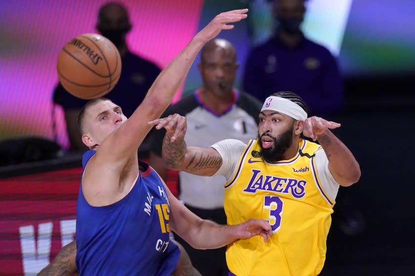 Denver Nuggets center Nikola Jokic (15) defends against a pass by Los Angeles Lakers' Anthony Davis.