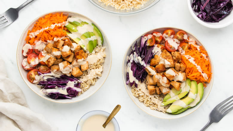 Two tofu grain bowls with dressing on