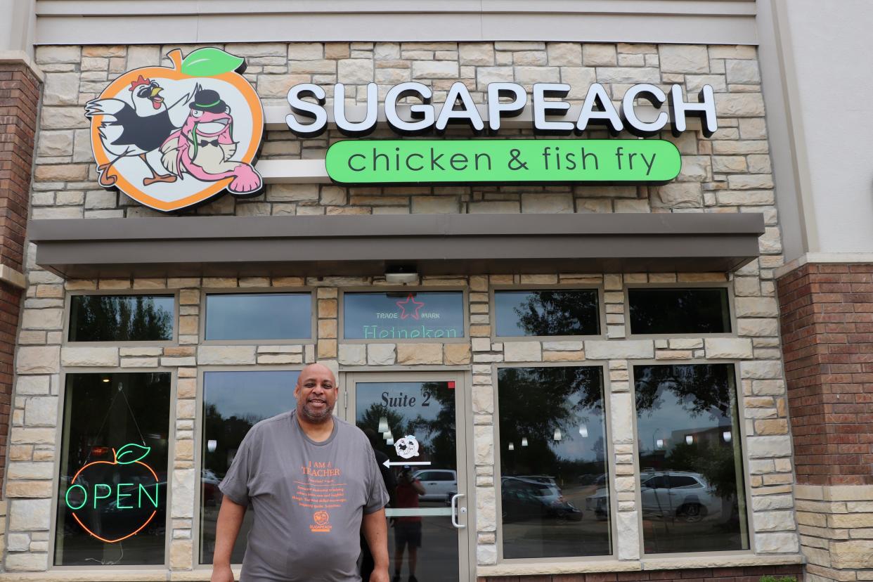 Chad Simmons, the newest member of Iowa City's Ad Hoc Truth and Reconciliation Commission, poses for a photo in front of Sugapeach Chicken & Fish Fry, the business he co-founded with his wife on Thursday, Aug. 3, 2023.