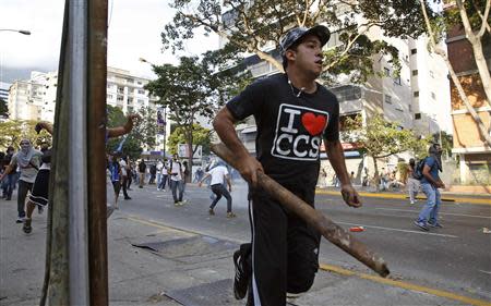 Demonstrators confront police as they protest against the government of President Nicolas Maduro in Caracas February 22, 2014. REUTERS/Carlos Garcia Rawlins