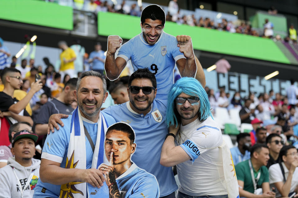 Uruguay soccer fans pose for a picture holding images of Uruguay's players Luis Suarez, above, and Darwin Nunez prior to the World Cup group H soccer match between Uruguay and South Korea, at the Education City Stadium in Al Rayyan , Qatar, Thursday, Nov. 24, 2022. (AP Photo/Martin Meissner)