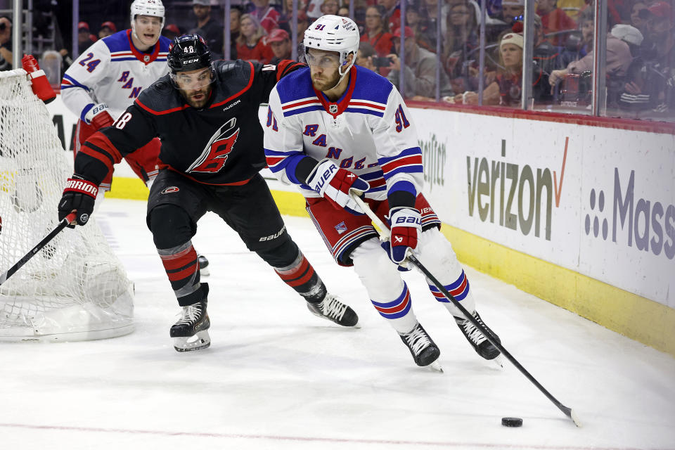 New York Rangers' Alex Wennberg (91) looks to pass the puck while chased by Carolina Hurricanes' Jordan Martinook (48) during the first period in Game 4 of an NHL hockey Stanley Cup second-round playoff series in Raleigh, N.C., Saturday, May 11, 2024. (AP Photo/Karl B DeBlaker)