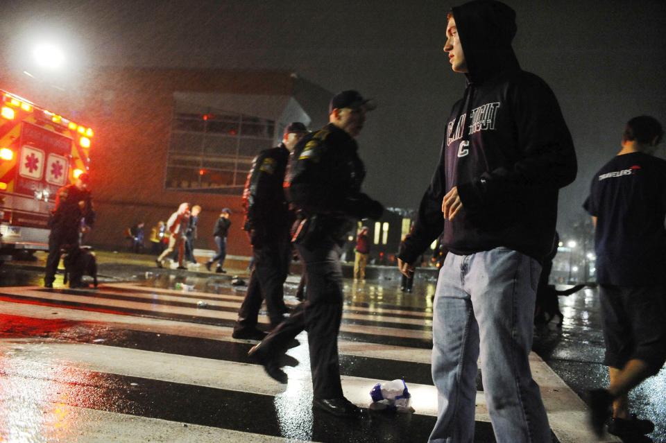 Connecticut State Police move students away from the student union area after they gathered to celebrate their team's 60-54 victory over Kentucky in the NCAA Final Four tournament college basketball championship game, Monday, April 7, 2014, in Storrs, Conn. (AP Photo/Jessica Hill)