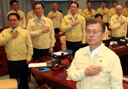 South Korean President Moon Jae-in salutes to the national flag during a cabinet meeting at the Presidential Blue House in Seoul, South Korea, August 21, 2017. Kim Ju-hyoung/Yonhap via REUTERS