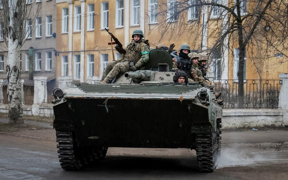 Ukrainian service members ride a BMP-1 infantry fighting vehicle in the front line city of Chasiv Yar - STRINGER/REUTERS