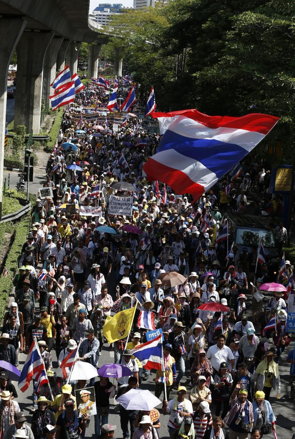 Anti-government protesters march on a main road to the prime minister's office compound in Bangkok, Thailand, Monday, May 12, 2014. The battle for who holds Thailand's seat of power took on a new twist Monday as leader of anti-government protests Suthep Thaugsuban planned to set up his office at the vacated Government House while the country's new caretaker leader worked from a makeshift, suburban outpost. (AP Photo/Vincent Thian)