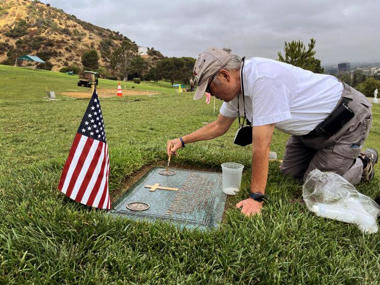 Los Angeles, California-Former Judge Lance Ito attends to the grave of his wife Margaret "Peggy" York, at Forest Lawn memorial park. "Peggy" died on October 17, 2021, at 80, after an illness. Ito brushes on bronze tablet oil to make it shine. (Steve Lopez / Los Angeles Times)