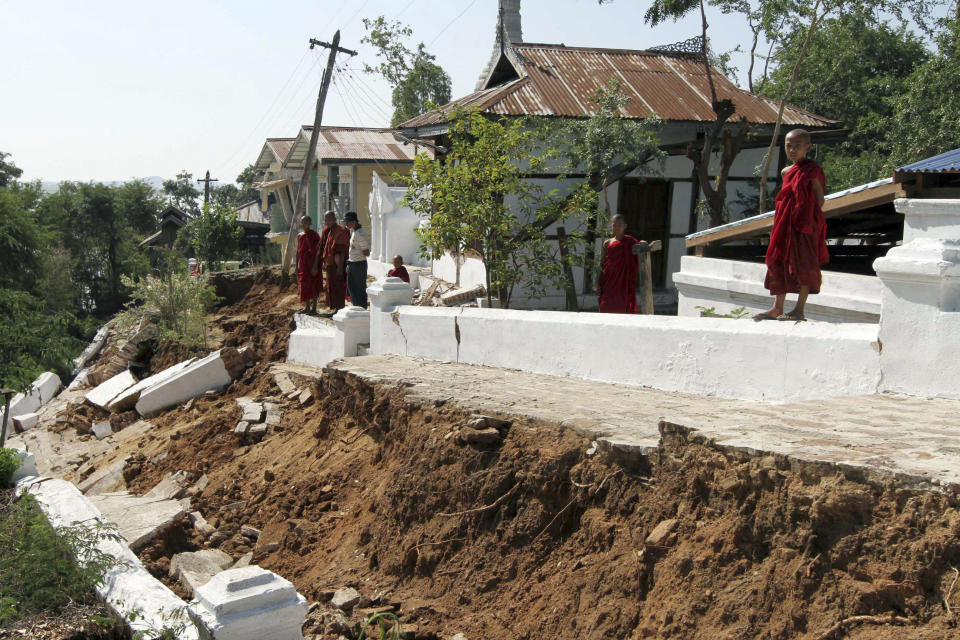 Myanmar Buddhist monks looks at the compound of a monastery damaged by Sunday morning's magnitude-6.8 quake in Kyaukmyaung township, Shwebo, Sagaing Division, northwest of Mandalay, Myanmar, on Monday, Nov. 12, 2012. The strong earthquake collapsed a bridge and damaged ancient Buddhist pagodas in northern Myanmar, and piecemeal reports from the underdeveloped mining region said mines collapsed and as many as 12 people were feared dead. (AP Photo/Khin Maung Win)