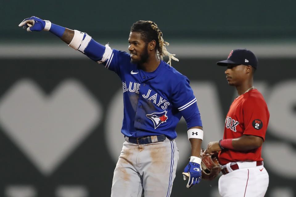 Toronto Blue Jays' Raimel Tapia gestures next to Boston Red Sox's Jeter Downs after hitting a two-run double during the fifth inning of a baseball game Friday, July 22, 2022, in Boston. (AP Photo/Michael Dwyer)