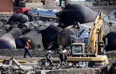 FILE PHOTO: Emergency workers work on the site of the train wreck after a runaway train carrying crude oil derailed and exploded in Lac Megantic, Quebec, Canada, July 12, 2013. REUTERS/Mathieu Belanger/File Photo