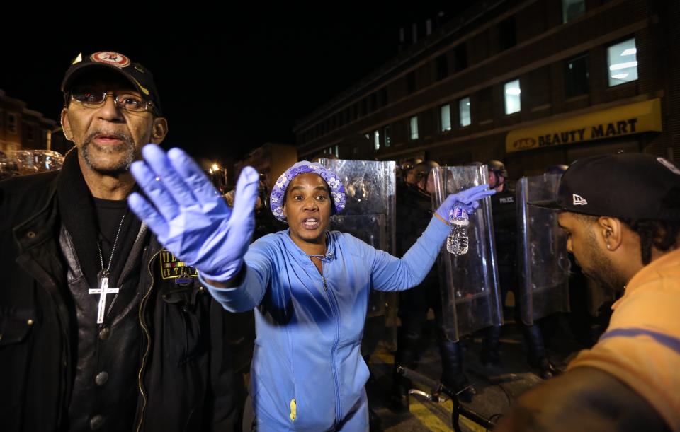 BALTIMORE, MD - APRIL 28:  A woman reacts during a curfew in Baltimore, Maryland, USA on 28 April 2015.  Tensions eased on 28 April after demonstrators kept rock-throwing protestors at bay from lines of police in riot gear. Hundreds of people were still out on the street after the 10 pm curfew passed. Police formed a wall against protestors who continued throwing plastic and glass bottles at them and officers threw smoke bombs and shot pepper spray pellets at the protesters. Demonstrations continue over the death of Freddie Gray, 25, an African-American who died on 19 April of injuries suffered in police custody. (Photo by Cem Ozdel/Anadolu Agency/Getty Images)