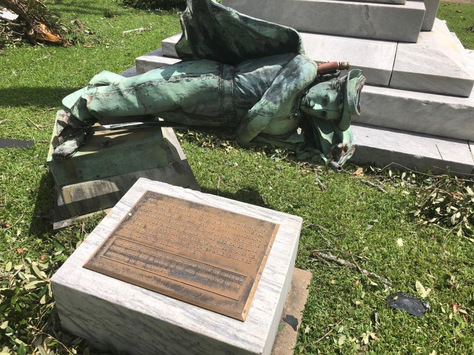 A statue of a Confederate soldier in front of a courthouse in Lake Charles, La., lies on the ground Thursday Aug. 27, 2020 after being toppled when Hurricane Laura ripped through the area. Earlier this month parish officials voted to keep the statue, called the South’s Defenders Monument, in its place. (AP Photo/Melinda Deslatte)
