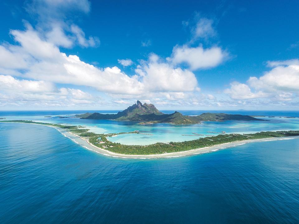 A bright blue body of water with an island