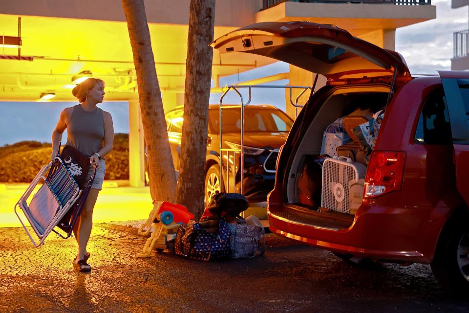 Brooke Painter loads personal items into a van as she and her family evacuate their vacation rental ahead of the possible arrival of Hurricane Idalia on August 28, 2023 in Tampa, Florida.