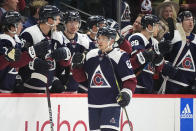 Colorado Avalanche left wing Artturi Lehkonen, front, is congratulated as he passes the team box after scoring a goal in the second period of an NHL hockey game against the Nashville Predators Saturday, March 30, 2024, in Denver. (AP Photo/David Zalubowski)